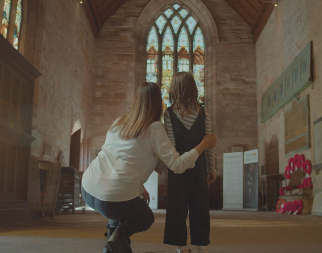 a lady and a child looking at stained glass windows