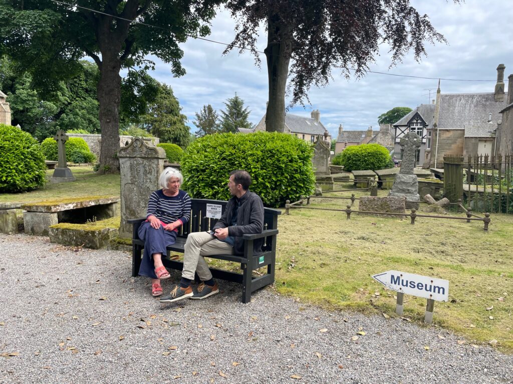 a couple of people sat chatting on a bench
