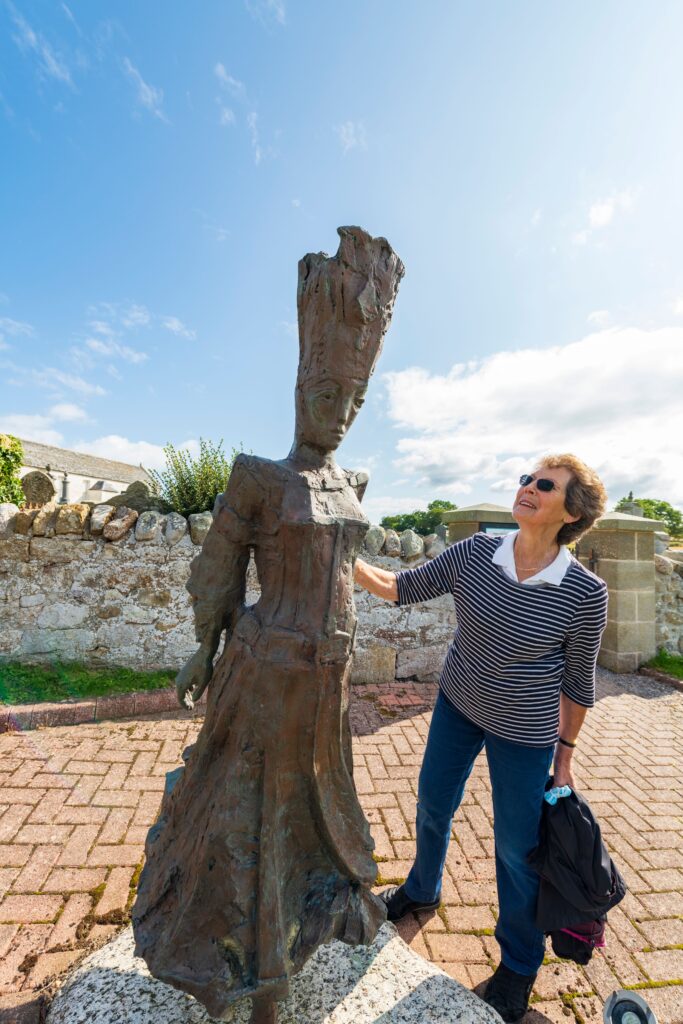 visitor standing with pictish queen statue